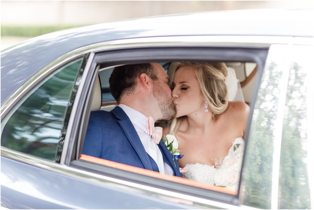 bride and groom kissing in the getaway car 