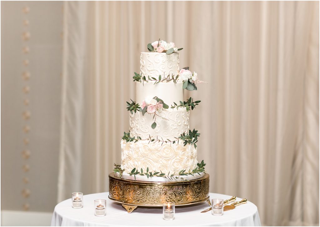 the artistic whisk wedding cake with pink and white florals