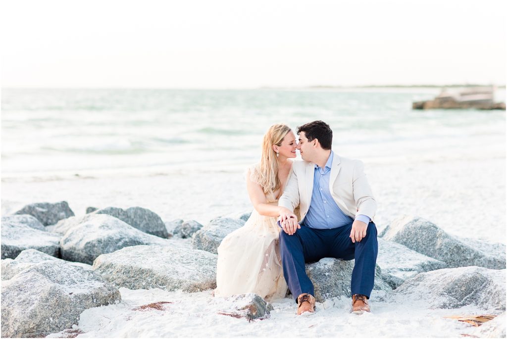 couple kissing by the pier on fort desoto beach