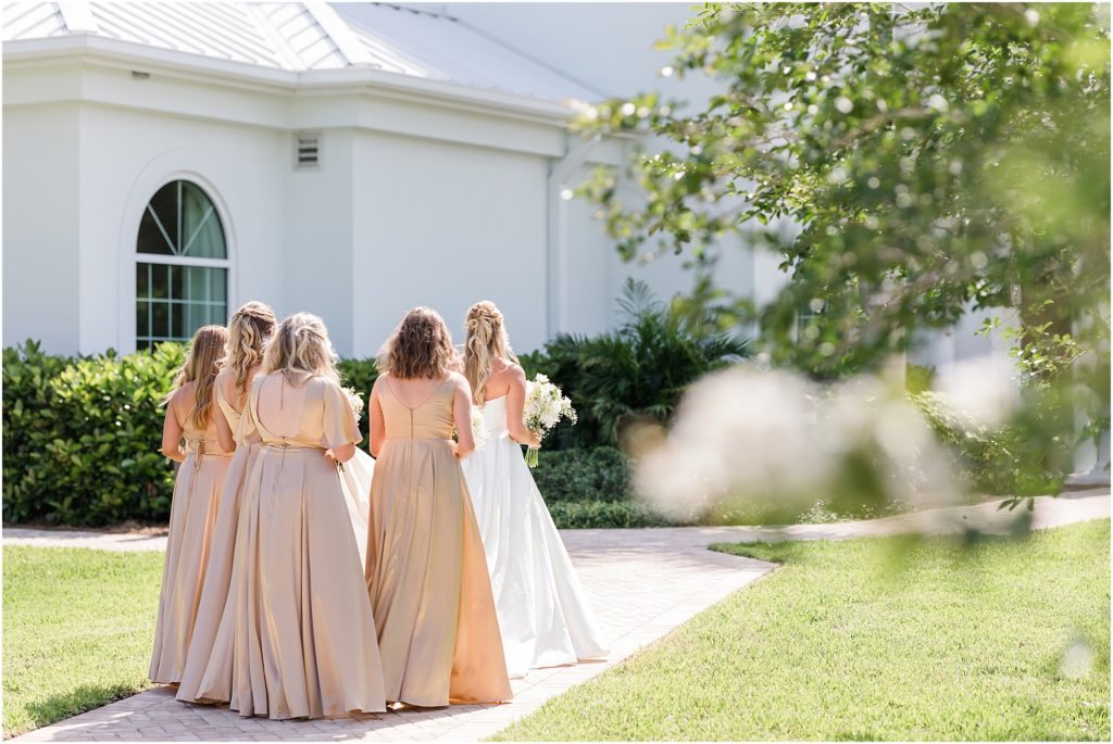 bridesmaids walking into white chapel