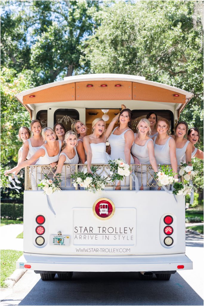 bridesmaids laughing in white star trolley 